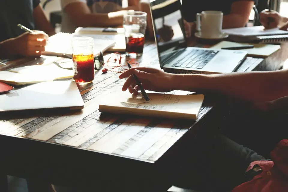 Colleagues around a table in a small business meeting, deciding which software seats to buy