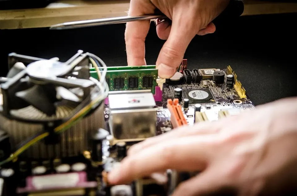 A technician working on computer hardware, a reminder that older PCs sometimes need replacing